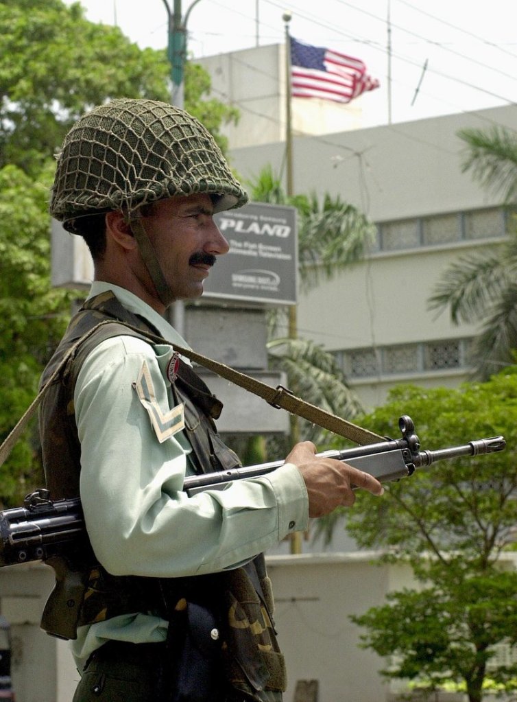 A paramilitary soldier guards the U.S. Consulate in Karachi, Pakistan, in 2002, after an attack in which 10 people died. There were several lethal attacks on U.S. diplomatic stations when George W. Bush was president, but Democrats didn't call for a "Watergate-style commission," as Republicans have in the Benghazi, Libya, attack, a reader says.