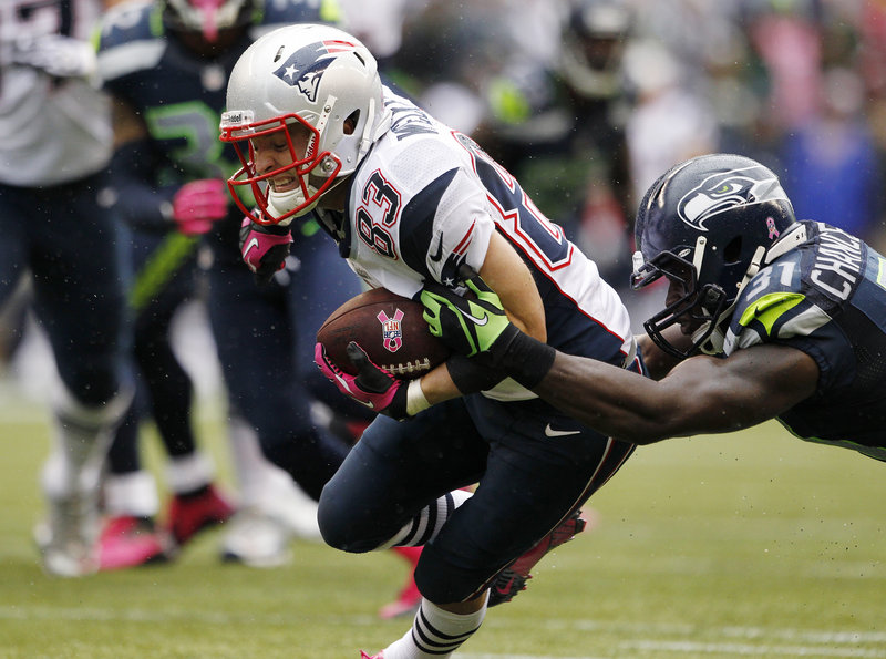 Wes Welker, shown here trying to break from the grasp of a Seattle Seahawk, has caught 66 passes this season, just three behind NFL leader Reggie Wayne, whose Colts come to Foxborough on Sunday.