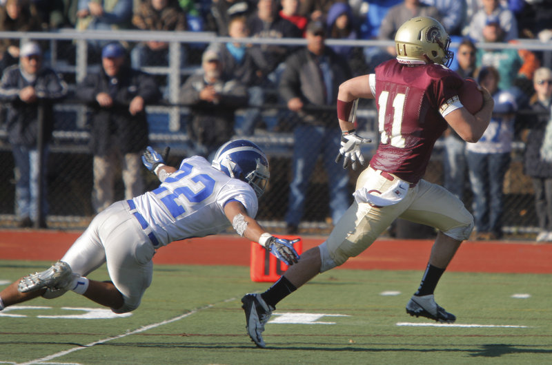 Thornton Academy quarterback Eric Christensen eludes a dive by Xavier Lewis of Lawrence and heads into the end zone to score on a 30-yard run Saturday – part of the spurt that produced a 37-23 victory in the Class A final at Fitzpatrick Stadium.