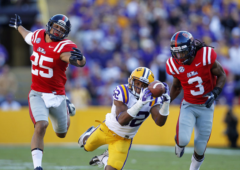 LSU wide receiver James Wright pulls in a 48-yard pass reception while sandwiched by Mississippi defensive backs Cody Prewitt (25) and Charles Sawyer (3) during the Tigers’ 41-35 victory in Baton Rouge, La., Saturday.