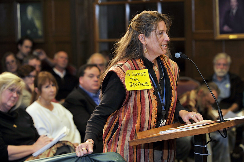 Donna Yellen of Preble Street holds a shelter mattress as she speaks to the council and challenges the notion that homeless people come to Portland for the services provided.