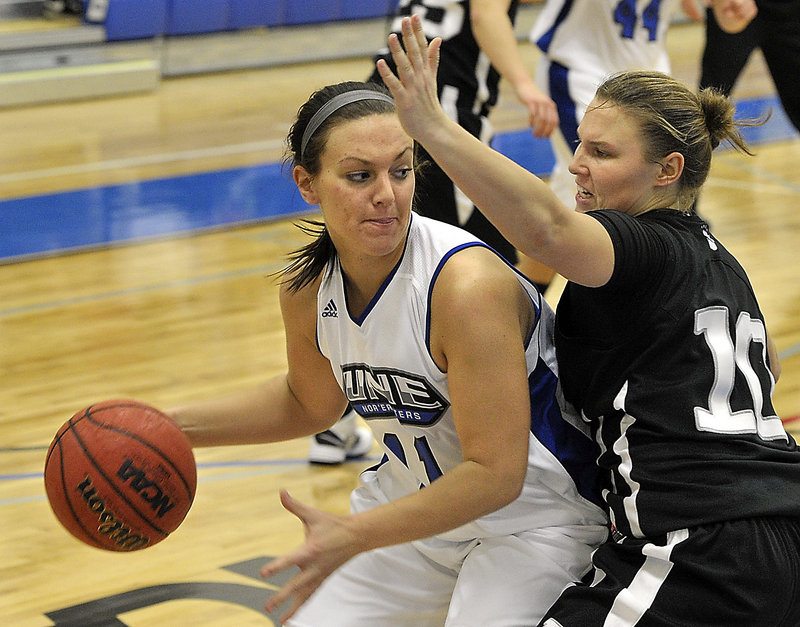 Liz LeBlanc of the University of New England looks for room to drive Tuesday night while pressured by Kirsten Prue of Bowdoin. UNE opened a new building by winning, 72-32.