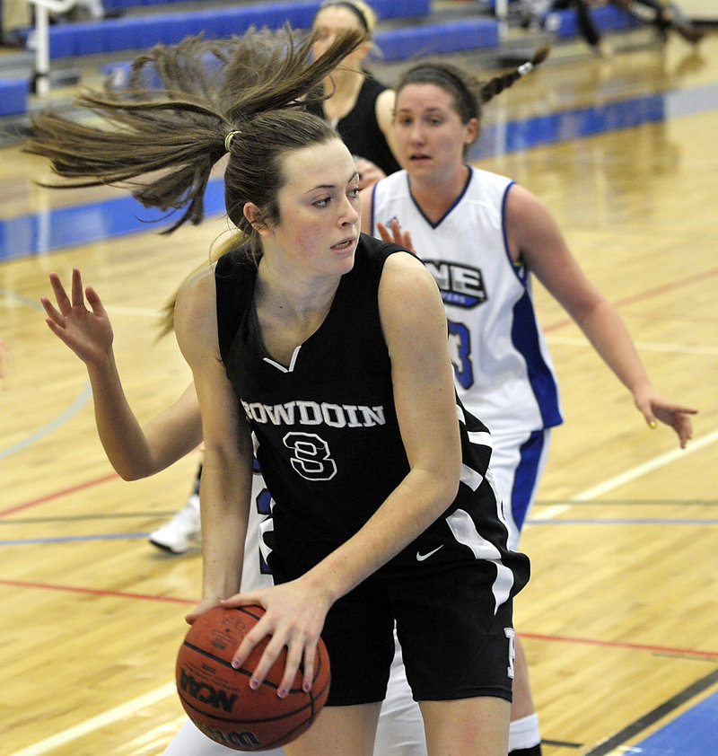 Shannon Brady of Bowdoin looks for a teammate to start the transition game after grabbing a rebound against UNE. Bowdoin dropped to 1-2; UNE is 2-1.