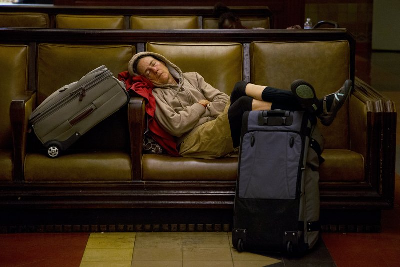 A traveler sleeps Wednesday at Union Station in Los Angeles. About 43.6 million Americans were expected to journey 50 miles or more between Wednesday and Sunday, a slight increase over last year, and evidence that Americans are continuing to recover from the recession of 2007-09.
