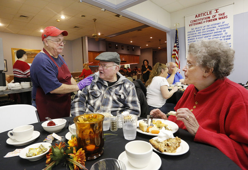 Host Carl Hubbard checks in on Jim and Carol Allen of South Portland on Thursday during the 17th annual Thanksgiving dinner held at VFW Post 832 in South Portland.