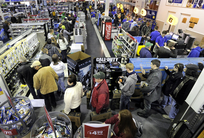 Best Buy's general manager Bart Gillespie, center, fires up his team before the South Portland store opened at midnight Thursday. The team tried to pace the number of shoppers allowed in at one time.