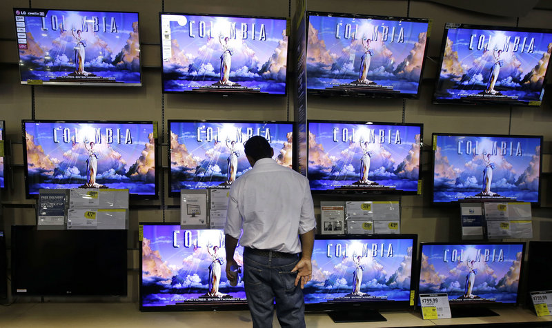 A shopper looks at televisions at a Best Buy store in Franklin, Tenn., after the store opened at midnight, kicking off Black Friday. Former executives are attempting to buy the troubled chain to take it private.