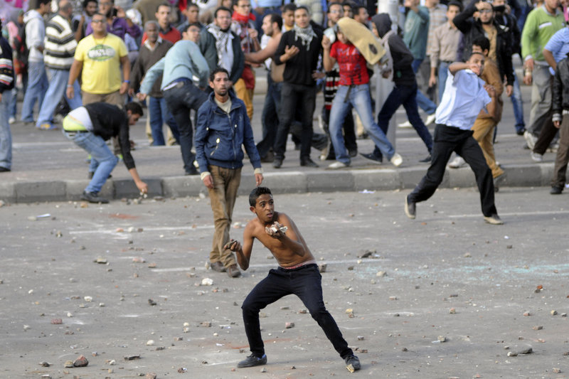 The Associated Press Protesters hurl stones during clashes between supporters and opponents of President Mohammed Morsi in Alexandria, Egypt, on Friday, the day after Morsi granted himself sweeping new powers that critics fear can allow him to be a virtual dictator. Thousands from the two camps threw stones and chunks of marble at each other outside a mosque.