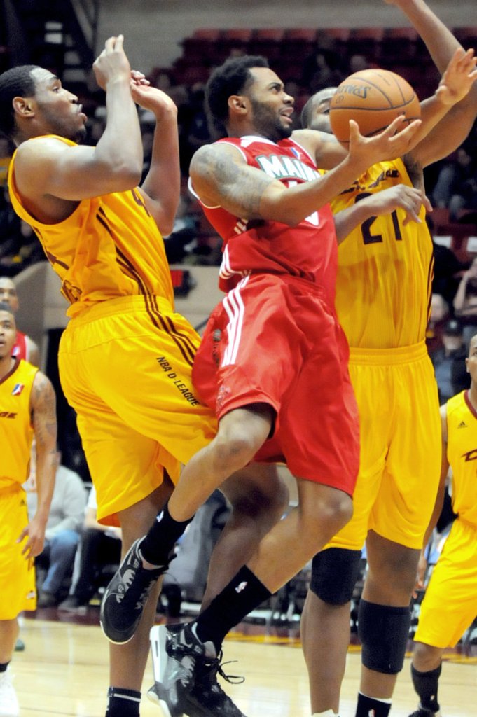 Xavier Silas of the Maine Red Claws drives to the basket between Kevin Jones, left, and Arinze Onuaku of the Canton Charge during the Red Claws’ 123-115 victory in an opener Friday night.