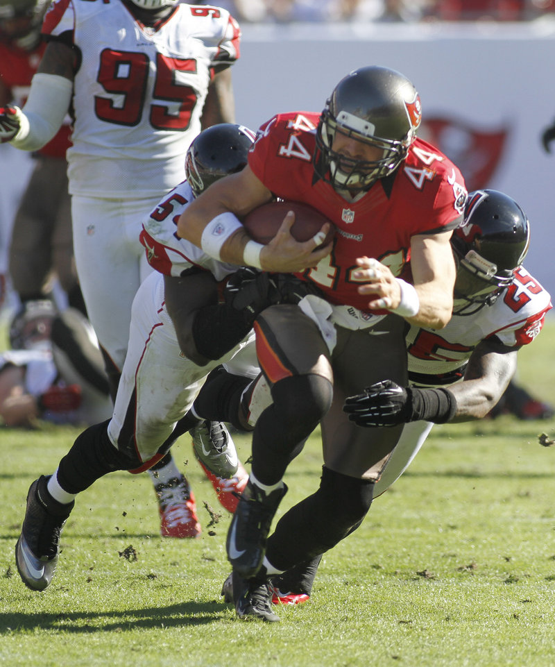 Dallas Clark, tight end for Tampa Bay, drags Atlanta defenders Stephen Nicholas (54) and William Moore (25) following a reception in Sunday’s loss to the Falcons.