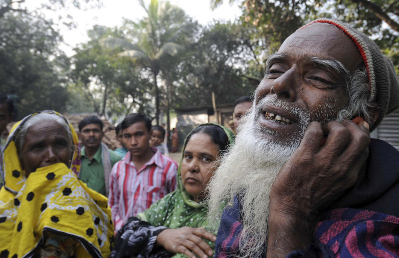 A Bangladeshi man grieves as he looks for his son’s body Monday outside a garment factory where a fire killed at least 112 people Saturday on the outskirts of Dhaka, Bangladesh.