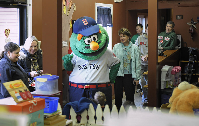 Wally the Green Monster, along with Red Sox players Mark Melancon, Ryan Kalish and Chris Carpenter visit the Briarwood Children's House on Tuesday as part of the team's holiday road trip.