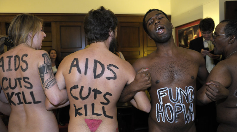 Naked AIDS activists, with painted slogans on their bodies, protest potential spending cuts in HIV programs Tuesday in the lobby of the Capitol Hill office of House Speaker John Boehner of Ohio ahead of World AIDS Day, Saturday.