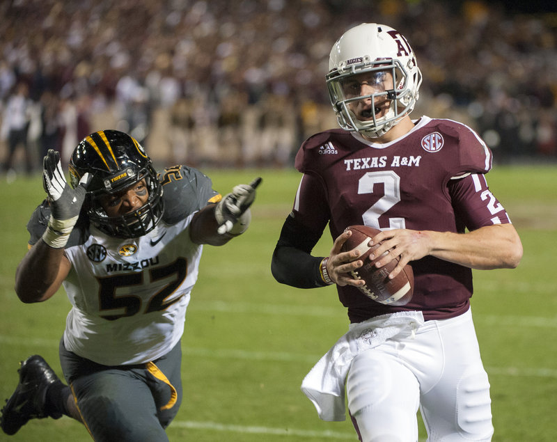 Johnny Manziel of Texas A&M, shown evading Missouri’s Michael Sam during last weekend’s 59-29 victory, could soon be the first freshman – albeit not a “true” one – to win the coveted Heisman Trophy.