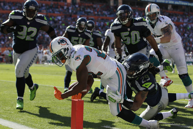 Reggie Bush, Miami running back, stretches into the end zone despite the efforts of Seattle safety Earl Thomas (29) during Sunday’s victory that leaves Miami at 5-6 and still in contention for an AFC wild-card berth as the season enters the homestretch.