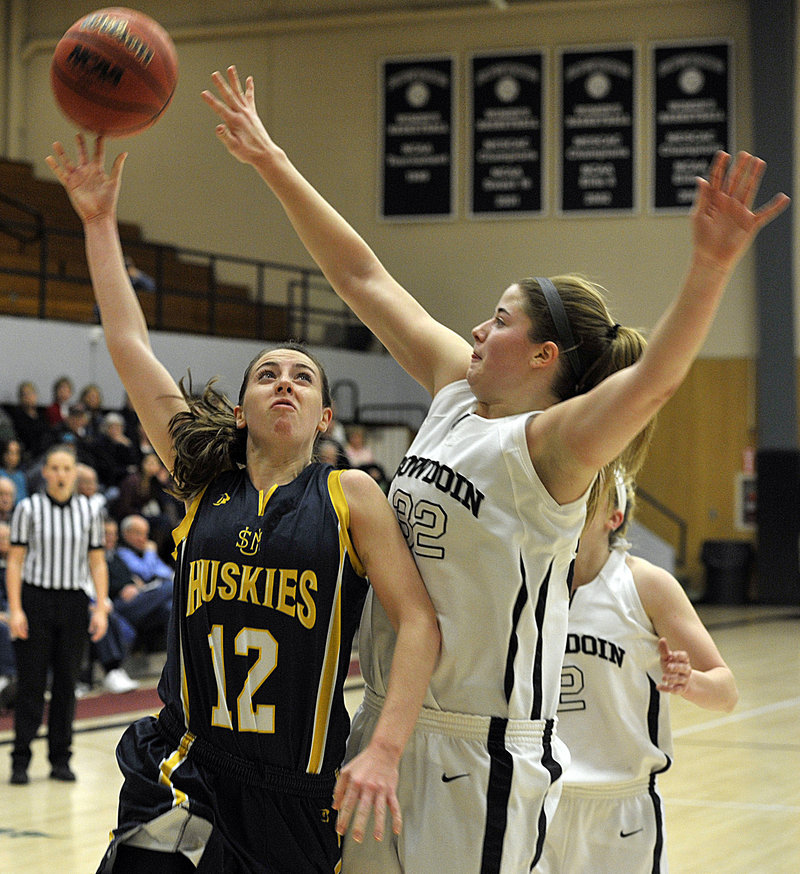 Erin McNamara of the University of Southern Maine, left, finds enough room to lift a shot over Megan Phelps of Bowdoin during their nonconference game Tuesday night, USM pulled away in the second half for a 72-58 victory.