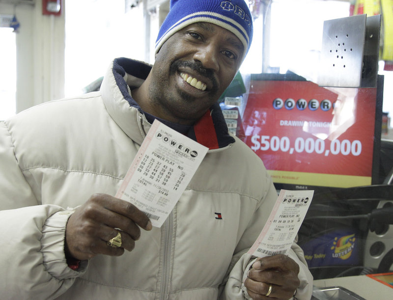 Lamar Fallie, 52, of Chicago buys six Powerball tickets at a BP gas station Wednesday in Calumet Park, Ill. He is unemployed and was lured by the $550 million jackpot.