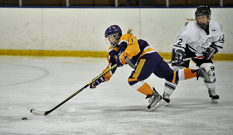 Sophia Giancotti of Cheverus gets tripped by Katie Rutherford of Portland-Deering in an 8-8 tie Wednesday night at Portland Ice Arena. Giancotti scored the first of three short-handed goals in the third period for the Stags.