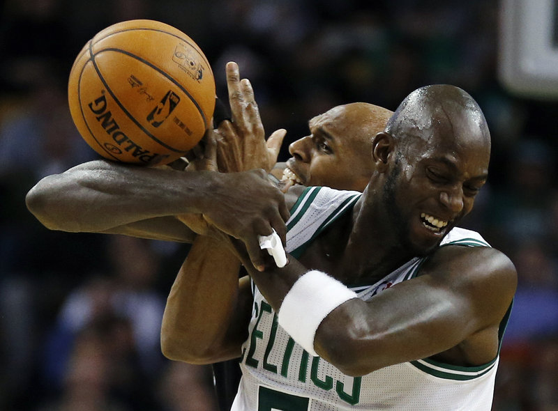 Kevin Garnett of the Celtics gets tangled with Jerry Stackhouse of the Nets while trying to control the ball.