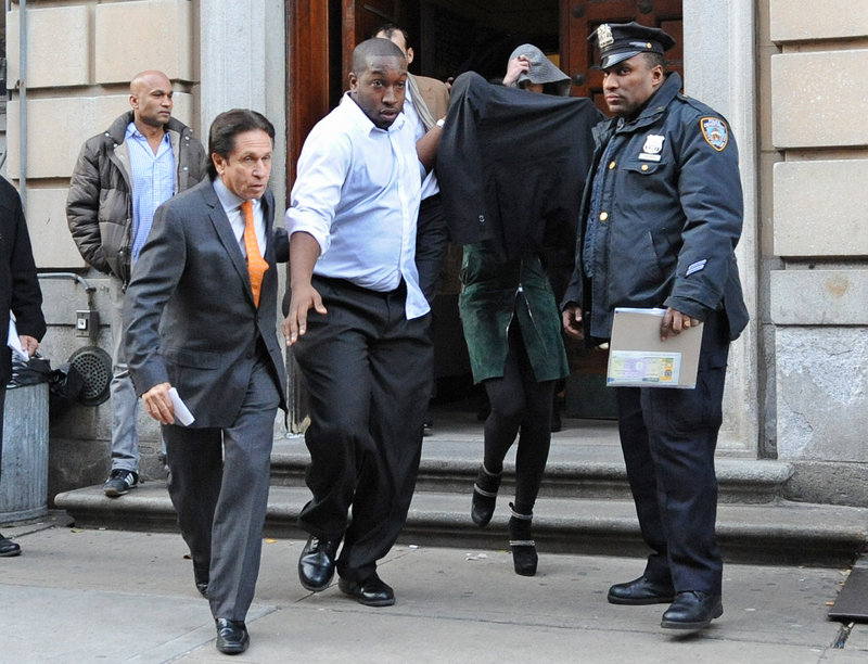 Lindsay Lohan is escorted from a New York City police station early Thursday morning with her face shielded.