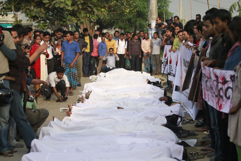 Activists lie on the ground wearing Muslim death robes in a protest at the Bangladesh Garment Manufacturers and Exporters Association building in Dhaka on Thursday.