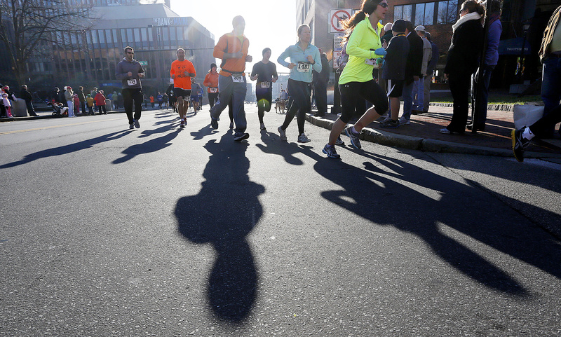 Participants in the Portland Thanksgiving Day 4-miler cast shadows on Temple Street on Thursday morning.