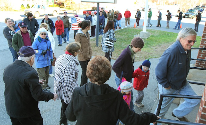 LINING UP TO VOTE: A long line of voters extends out the door of the Bourque-Lanigan American Legion Post 5 shortly after the polls opened in Waterville on Tuesday. High voter turn out is expected today.