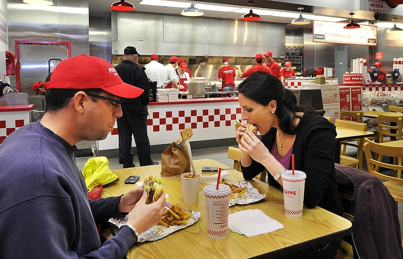 In this April 2011 file photo, Steve St. Jean and Leah Halsey from Portland taste the famous cheeseburgers and fries at the Five Guys Grand Opening at 425 Fore Street.