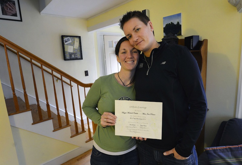 Alisson Poisson and Maggie Oechslie of South Portland hold a marriage certificate that Maggie's father made and presented to them in June 2011. Now that it's law, the couple looks forward to getting a legal certificate. Falmouth and Portland have said they will open at midnight Dec. 29 to accommodate requests from residents eager to get married at the earliest possible moment.