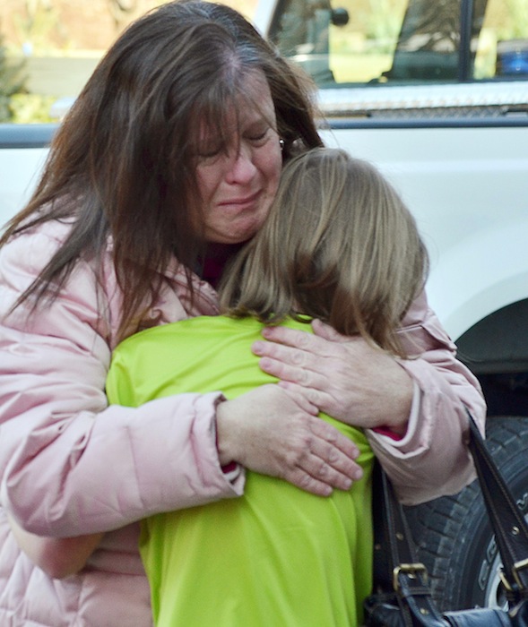 A mother hugs her daughter following a shooting at the Sandy Hook Elementary School in Newtown, Conn., about 60 miles (96 kilometers) northeast of New York City, Friday, Dec. 14, 2012. An official with knowledge of Friday's shooting said 27 people were dead, including 18 children. It was the worst school shooting in the country's history. (AP Photo/The New Haven Register, Melanie Stengel)