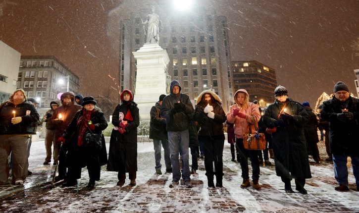 A crowd braves the weather to participate in a candlelight vigil in Portland's Monument Square for the victims of Friday's shooting in Newtown, Conn.