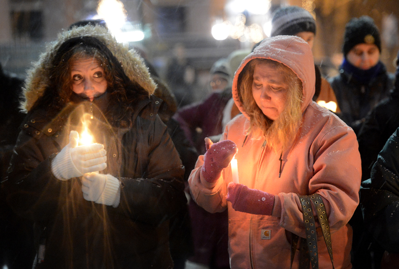 Julie Parker, left, and Alisa Dunham, both of Portland, were among the 200 who attended a vigil Sunday at Monument Square in Portland to support victims of Friday’s school shooting in Newtown, Conn.