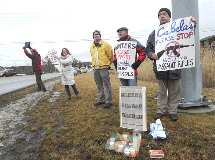 A small group led by Steve Swift of Vassalboro, right, protests the sale of assault rifles at Cabela's in Scarborough on Friday