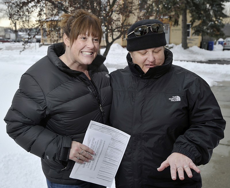 Heidi Caton holds the marriage license and her partner, Julie Nowell, looks at her rings as same-sex couples received marriage certificates at South Portland City Hall on Saturday. The wedding ceremony was planned for Saturday afternoon.