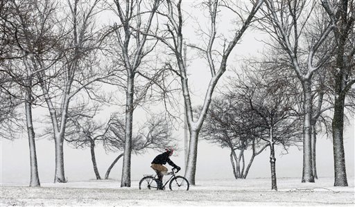 A lone cyclist navigates the bike path through a snow storm at Chicago's North Ave. beach Thursday, Dec. 27, 2012. A muted version of the deadly winter storm that has killed more than a dozen across the eastern half of the country reached the Northeast on Thursday, limiting most of its wrath to travel headaches as Christmas revelers tried to return home. (AP Photo/Charles Rex Arbogast)