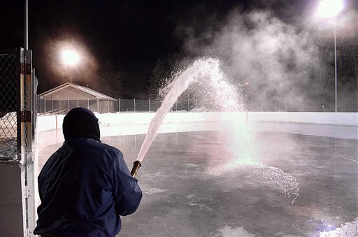 With temperatures in the single digits, city parks and recreation employee Greg Pecha floods a hockey rink Wednesday evening, Dec. 26, 2012 at Roosevelt Park in Eau Claire, Wis. Skating rinks in the city are opening a bit later than usual due to above-average temperatures earlier in the month. (AP Photo/Eau Claire Leader-Telegram, Steve Kinderman).