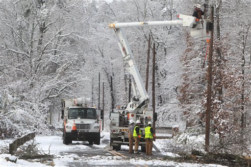 An Entergy Arkansas Inc., crew works to restore power to customers on Whittington Avenue near the entrance to Hot Springs National Park, Thursday, Dec. 27, 2012, in Hot Springs, Ark. A Christmas Day storm dumped between 6 to 15 inches of snow knocking out power to about half of the 61,000 customers in Garland County. (AP Photo/The Sentinel-Record, Richard Rasmussen)