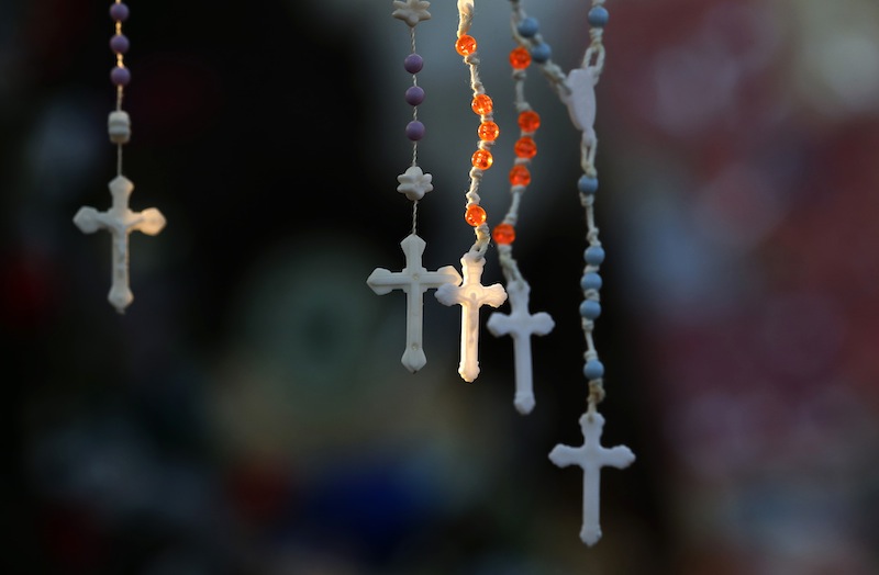 Rosaries are lit by the morning light on a makeshift memorial near the town Christmas tree in the Sandy Hook village of Newtown, Conn., Wednesday. The memorial, which was put up in the aftermath of the elementary school shooting that shocked the small town, is increasing in size as the days go on.