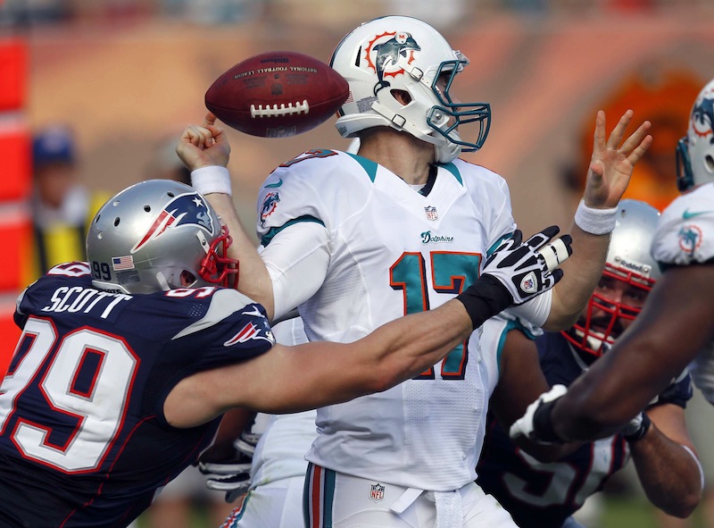 Miami Dolphins quarterback Ryan Tannehill (17) fumbles the ball after being hit by New England Patriots defensive end Trevor Scott (99) during the first half of an NFL football game, Sunday, Dec. 2, 2012 in Miami. (AP Photo/Wilfredo Lee) NFLACTION12;