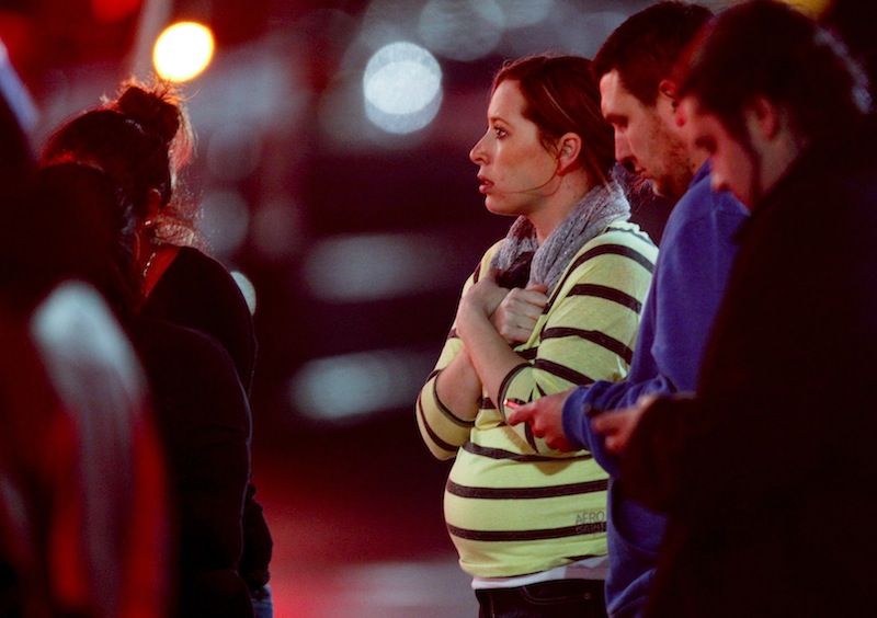 Onlookers gather outside Clackamas Town Center in Clackamas, Ore., where a gunman opened fire at a shopping mall Tuesday.