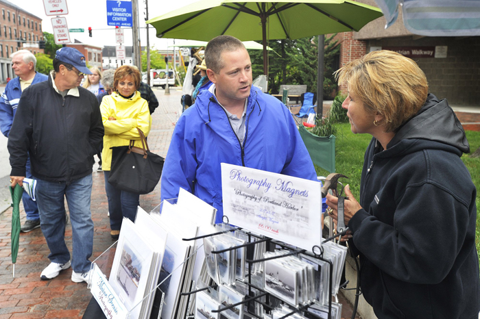 In this June 5, 2012, photo, Portland code enforcement officer Chuck Fagone talks with Tara Michaud about new regulations for street vendors using city sidewalks to sell their wares to cruise ship passengers.