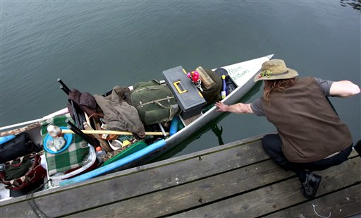 Michael Richard Smith steadies his canoe at a wharf in Boston Harbor on Tuesday.