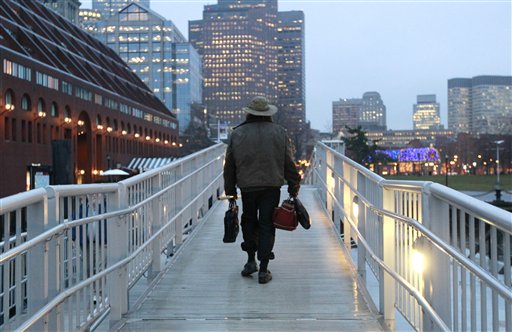 Michael Richard Smith carries a briefcase and a satchel as he walks up a gangway at a wharf in Boston Harbor.