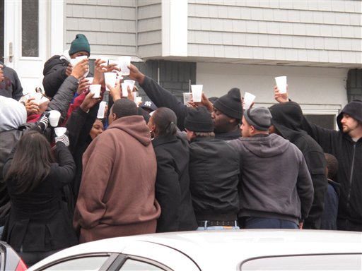 Friends and relatives of Jovan Belcher drink a toast outside the player's home on Saturday in West Babylon, N.Y.