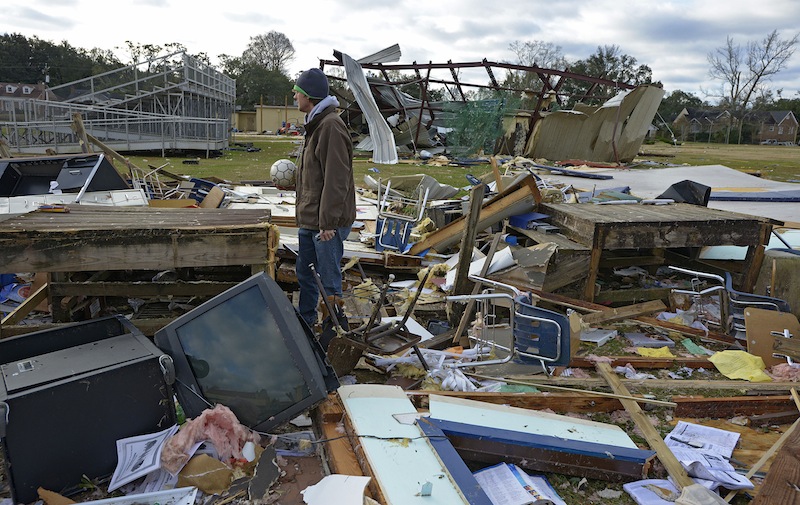 Murphy High School teacher Leland Howard tries to salvage items where his algebra classroom once stood in a temporary building at Murphy High School as residents clean up and assess the damage from a Christmas Day tornado Wednesday, Dec. 26, 2012 in Mobile, Ala. With only a handful of injuries and no deaths reported statewide from the storms, the head of the state's emergency response said it was difficult to fathom how the toll wasn't worse. (AP Photo/G.M. Andrews)