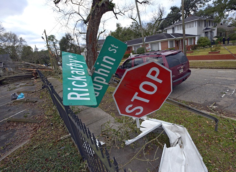 A street sign is bent at a severe angle from a Christmas Day tornado as residents clean up and assess the damage Wednesday, Dec. 26, 2012 in Mobile, Ala. With only a handful of injuries and no deaths reported statewide from the storms, the head of the state's emergency response said it was difficult to fathom how the toll wasn't worse. (AP Photo/G.M. Andrews)
