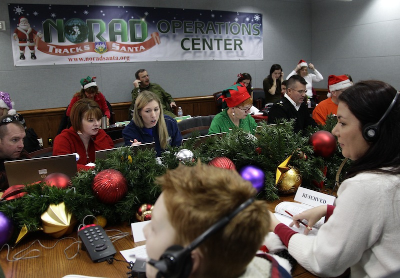 Volunteers take phone calls from children asking where Santa is and when he will deliver presents to their house, during the annual NORAD Tracks Santa Operation, at the North American Aerospace Defense Command, or NORAD, at Peterson Air Force Base, in Colorado Springs, Colo., Monday Dec. 24, 2012. Over a thousand volunteers at NORAD handle more than 100,000 thousand phone calls from children around the world every Christmas Eve, with NORAD continually projecting Santa's supposed progress delivering presents. (AP Photo/Brennan Linsley)