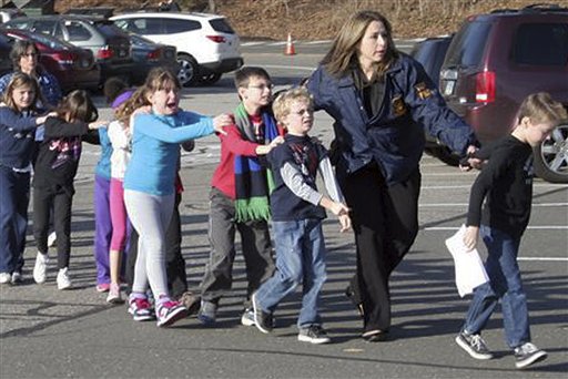 In this photo provided by the Newtown Bee, Connecticut State Police lead children from the Sandy Hook Elementary School in Newtown, Conn., following a reported shooting there on Friday.