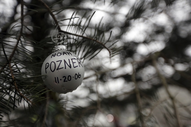 An ornament for Noah Pozner hangs on a tree at one of the makeshift memorials for the Sandy Hook Elementary School shooting, Monday, Dec. 17, 2012 in Newtown, Conn. Pozner was killed when a gunman walked into Sandy Hook Elementary School in Newtown Friday and opened fire, killing 26 people, including 20 children. (AP Photo/Mary Altaffer)