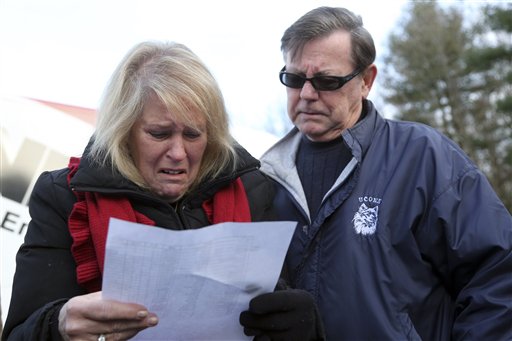 Kathy Murdy, left, and her husband, Rich, react Saturday in Newtown, Conn., as they look at the list of victims of the Sandy Hook Elementary School shooting.